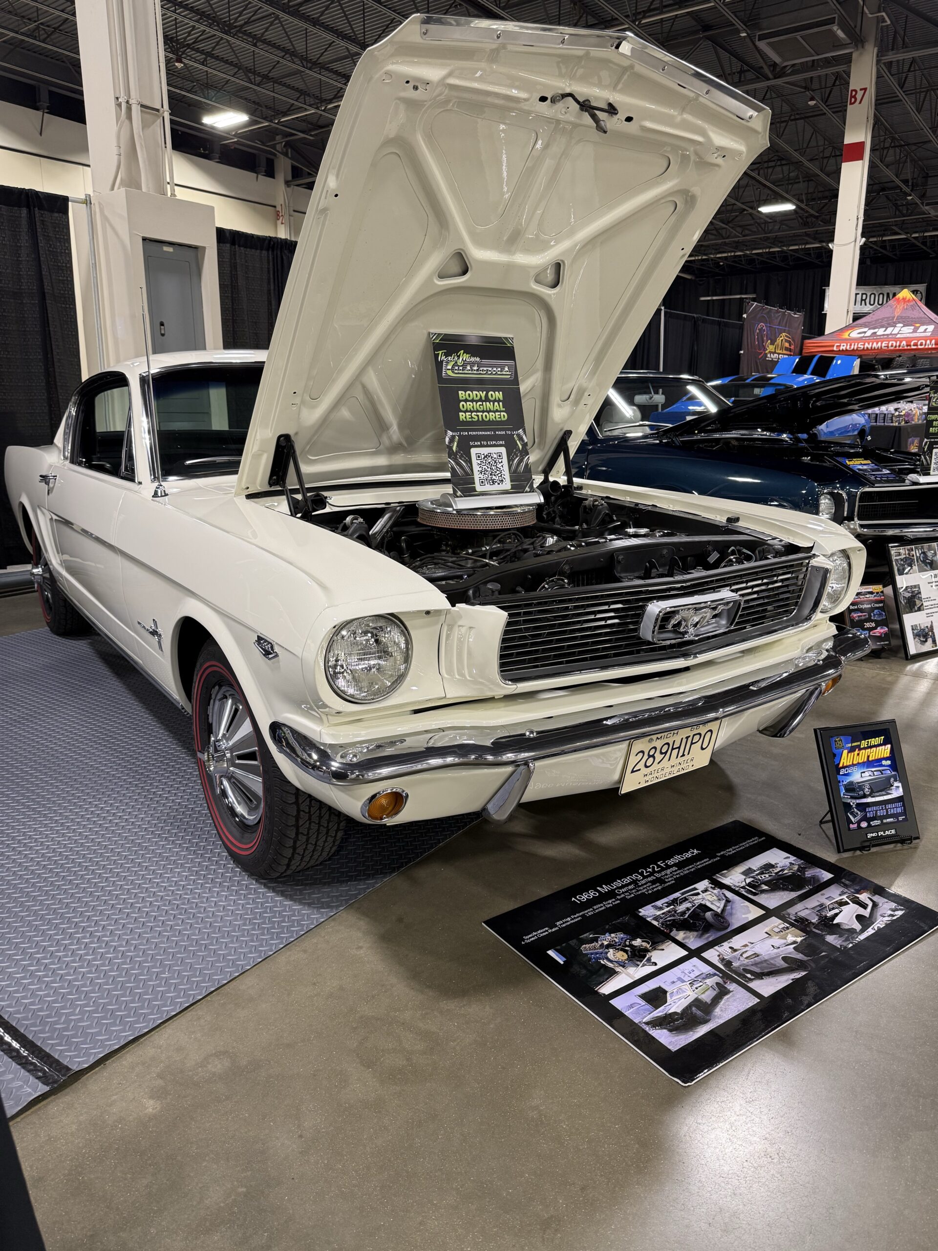 Jim Burgess’s restored white 1966 Mustang Fastback on display with its hood open