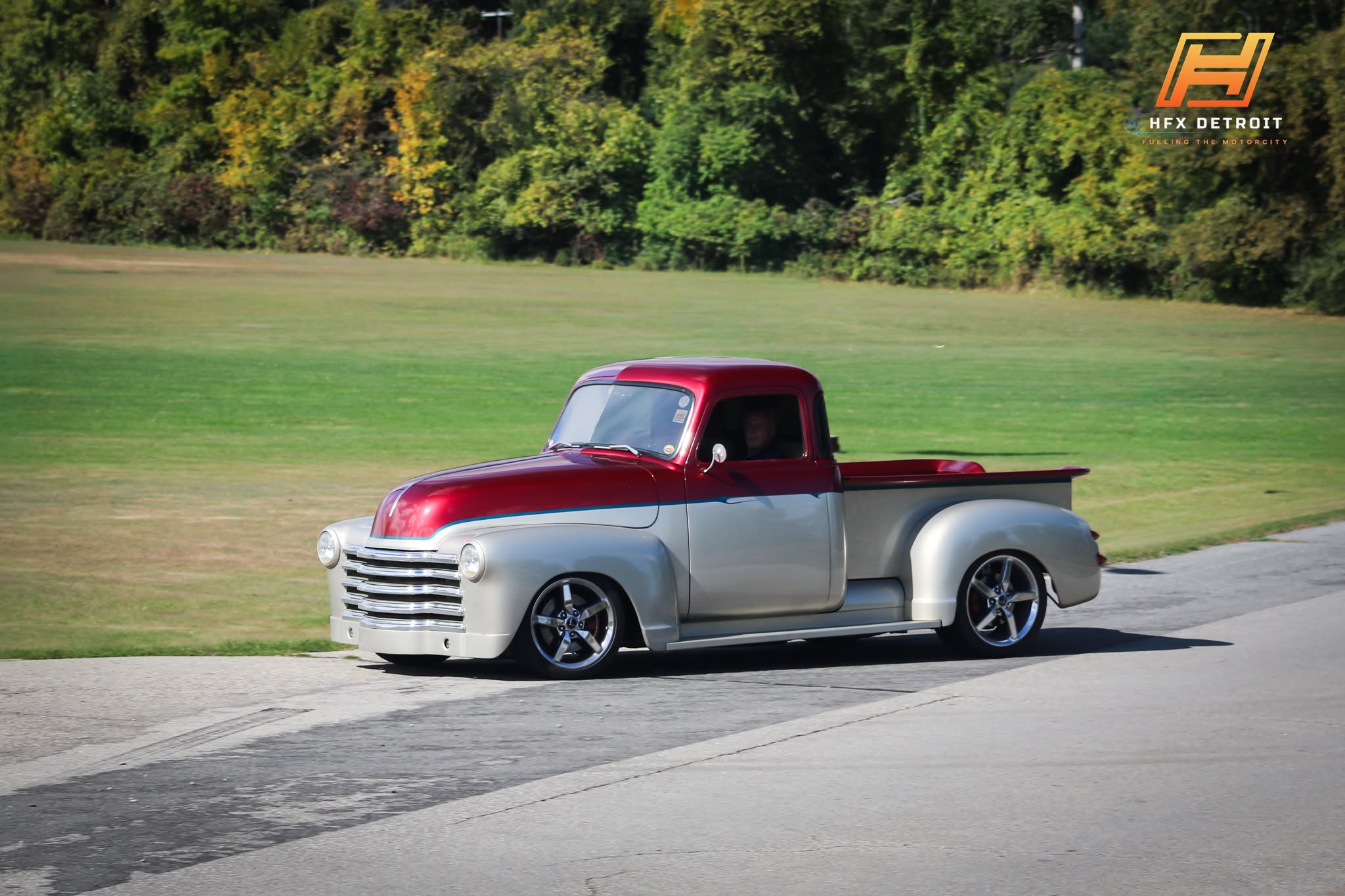 Stan Jesionowski’s red-and-silver classic pickup cruising in the sunshine, with bodywork and paint by That’s Minor Customs.